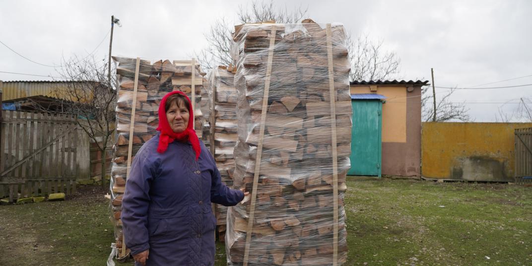 Woman standing with logs 